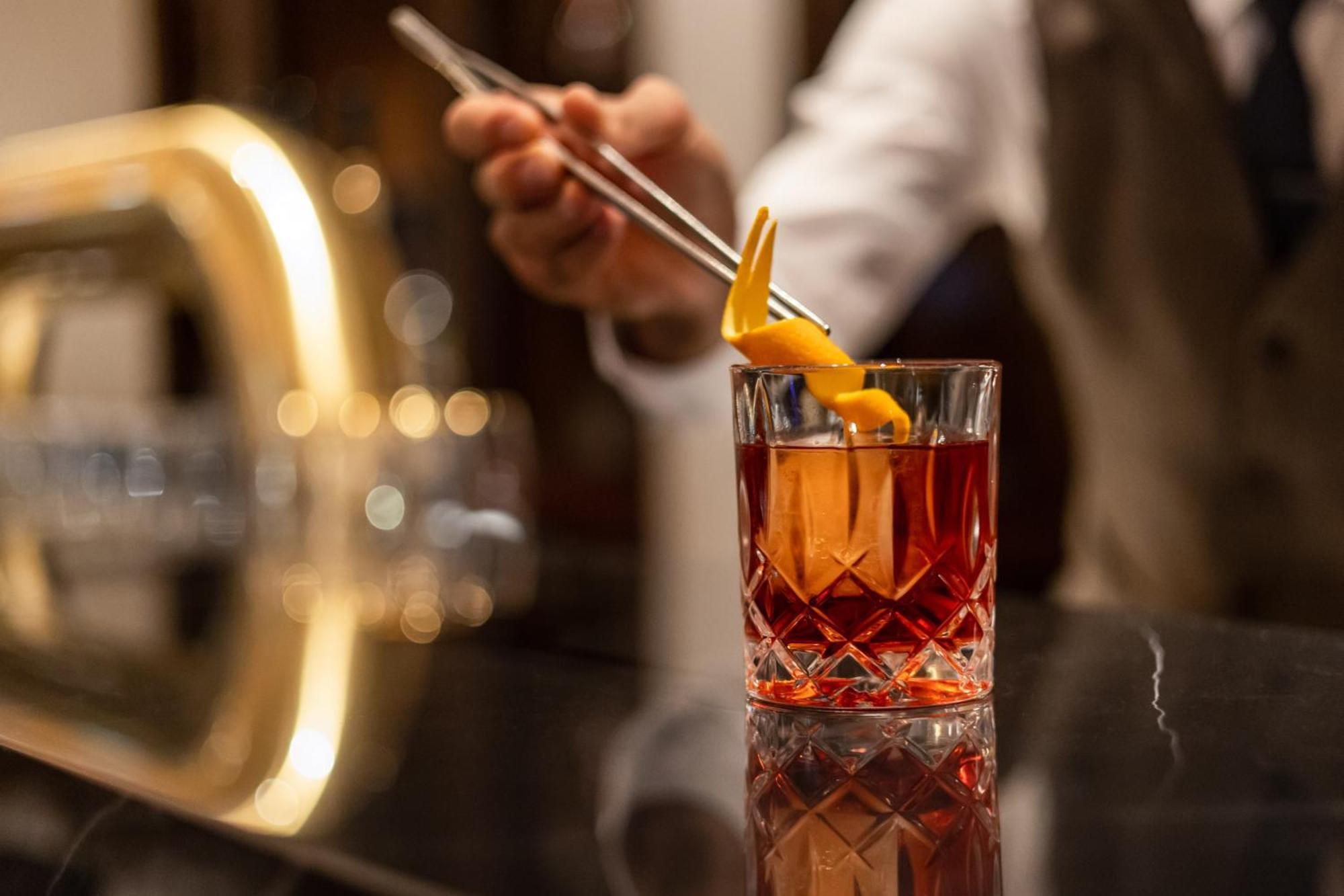 فندق إنتركونتيننتال برلين المظهر الخارجي الصورة A bartender adding a lemon twist to a cocktail